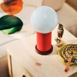 چراغ رومیزی بی‌سیم و قابل حمل ایکیا مدل PS 2026 با رنگ بدنه قرمز و آبی روشن دارای دیمر